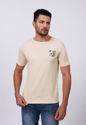 T-shirt en coton beige à manches courtes et col rond ; présente une broderie colorée de panda sur la poitrine gauche.