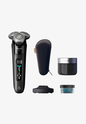 Elektrisch scheerapparaat Philips i9000 in zwart met zilveren accenten, vergezeld van een zwarte draagtas, een crèmepotje, een oplaadstation en een klein potje.