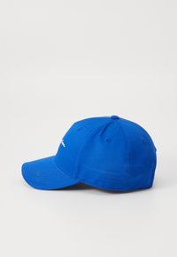 Blå bomull baseball cap med strukturert krone, buet skjerm og brodert logo foran. Seks ventilasjonshull på toppen.