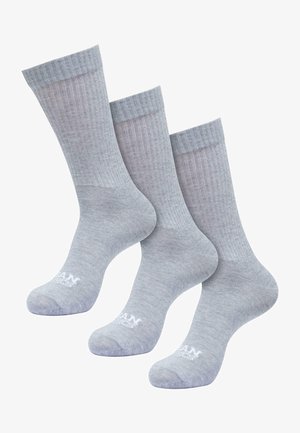 Calzini grigi a coste con una texture liscia, dotati di un bordo superiore di colore contrastante e un logo sulla base. Confezione da tre paia.