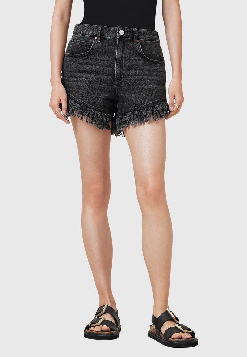 Shorts in denim nero con orlo sfrangiato, design a vita alta, stile a cinque tasche e dettagli metallici a contrasto. Abbinati a sandali neri.