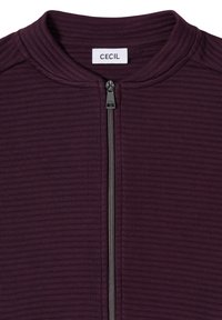 Donkerpaarse jas met ritssluiting en een geribbelde structuur. Heeft een hoge kraag en een contrasterende metallic rits. Label met de tekst "CECIL."