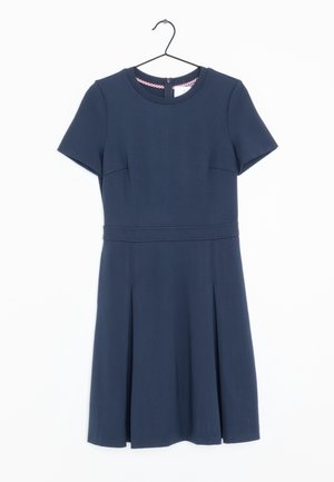 Robe bleu marine à manches courtes avec encolure ronde, taille cintrée et jupe plissée, suspendue à un cintre noir.