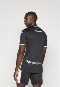 Juoda sportinė marškinėlių su trumpomis rankovėmis, geltonais ir mėlynais apvadais, gale su užrašu „1860 MÜNCHEN“ ir apačioje logotipu „pangaea.li".