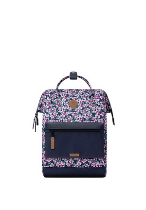 Rechteckiger Rucksack mit rosa und lila Blumenmuster, vordere navyblaue Tasche mit Reißverschluss und kleinem oberen Griff mit Druckknopfverschluss.