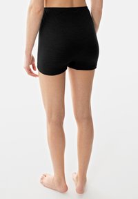 Shorts en coton noir à côtes avec taille haute, présentant un design sans coutures et une texture douce, vus de dos sur fond uni.