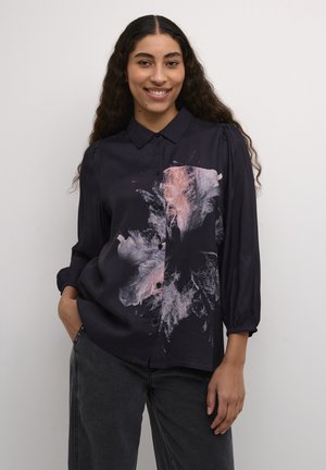 Cămașă neagră cu nasturi, prezentând un print abstract colorat pe partea stângă; mâneci lungi cu manșete pliate; textură netedă.