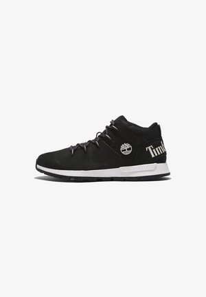Czarny półwysoki sneaker Timberland z białą podeszwą, logo drzewa z boku i napisem „Timberland” na pięcie, widziany z zewnętrznej strony.