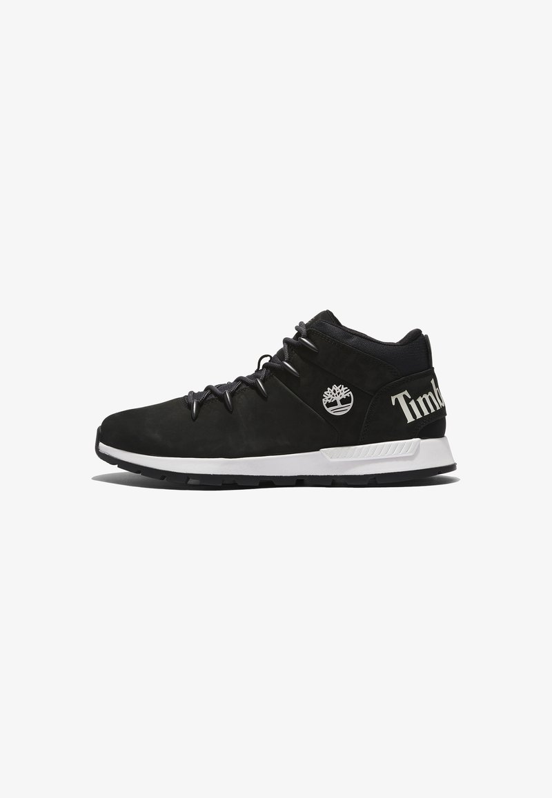 Baskets Timberland mi-hautes noires avec semelle blanche, logo arbre sur le côté et inscription "Timberland" au talon, vues de l'extérieur.