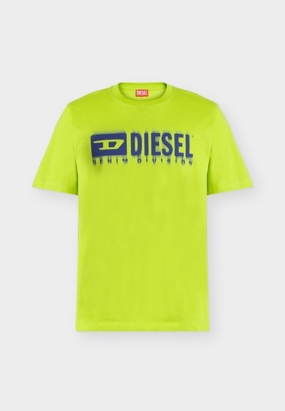 Ярка лаймено зелена тениска с къс ръкав с лого на Diesel в синьо и текст "Denim Division" отпред, показана на бял фон.