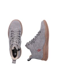 Graue Leder Stiefeletten mit einer strukturierten braunen Gummisohle. Sie verfügen über Schnürsenkel, ein weiches Innenfutter und ein kleines rotes Akzentdetail.