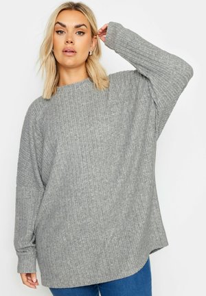 Grauer gerippter Oversized-Pullover mit langen Ärmeln und weitem Ausschnitt, der ein strukturiertes Strickmuster und eine entspannte Silhouette aufweist.