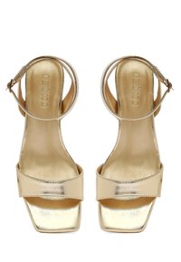 Gouden hoge hakken sandalen met een metallic afwerking, open teen ontwerp, brede band over de voorvoet en een enkelband voor ondersteuning.