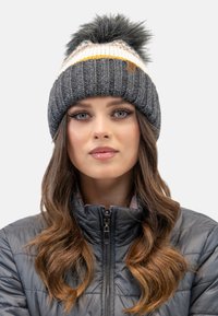 Grijze gebreide beanie met een witte en gele streep, afgewerkt met een zwarte bont pompon. Heeft een gestructureerd ribbelpatroon en een leren label.