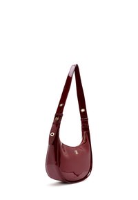 Bordeaux glanzende handtas met een gebogen, gestructureerde vorm. Beschikt over een lange strap met gouden hardware en een ritsvak.