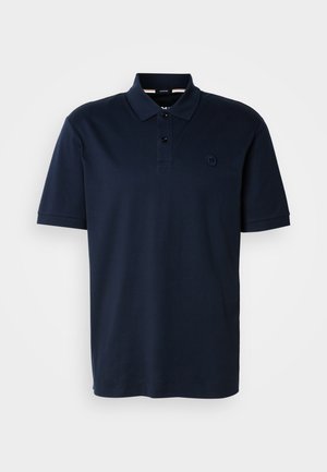 Polo majica temno modre barve iz bombaža, z ovratnikom, zapenjanjem na tri gumbe in majhnim logotipom na levem prsnem žepu. Kratki rokavi.