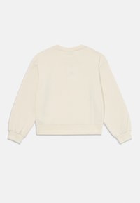 Sudadera color crema con mangas largas, puños acanalados y un corte relajado. Tejido suave con una textura lisa. Diseño minimalista, sin logotipo visible.