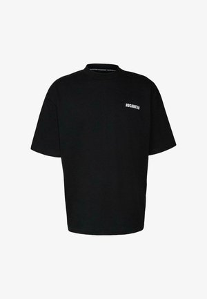 Must musta t-särk, mis on valmistatud puuvillast. Omab ümarat kaelusest ja väikest valget "ROCAWEAR" logo ees.