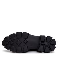 Semelle de botte noire robuste avec des crampons profonds, motifs de grip rectangulaires et en forme de losange pour une traction et une durabilité accrues.