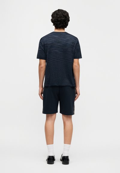 Navy ριγέ κοντομάνικη μπλούζα, σε συνδυασμό με σκούρο σορ τς. Διαθέτει άνετη εφαρμογή, μαλακό ύφασμα και λεπτή υφή.