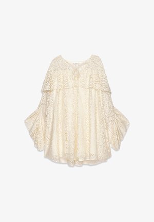 Spitzenoberteil in Off-White mit rundem Ausschnitt, geschichteten Rüschenschößchen und einer Bindeschleife vorne. Aufwändiges florales Muster über das gesamte Oberteil.