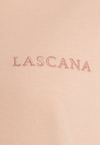 Hellrosa Stoff mit einer glatten Textur, auf dem in dunklerem Rosa der Schriftzug "LASCANA" mittig aufgestickt ist.