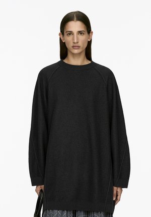 Dunkelgrauer, übergroßer Pullover mit Rundhalsausschnitt, Raglanärmeln und geripptem Saum. Hergestellt aus einem weichen, strukturierten Material.