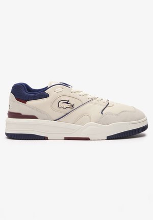 Beige leren sneakers met marineblauwe en bordeauxrode accenten, voorzien van mesh-secties, ronde veters, een logo aan de zijkant en een gestructureerde rubberen zool.