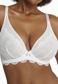 White lace bra with triangular cups, scalloped edges, and adjustable straps. Semi-sheer fabric with floral lace pattern detail.