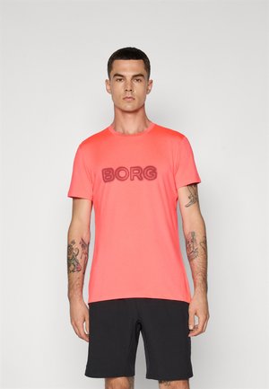 Kortærmet koralfarvet T-shirt med "BORG" trykt i en mørkere nuance, parret med sorte shorts. Glat stof og almindelig pasform.