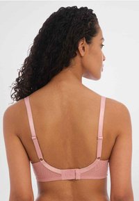 Soutien-gorge rose avec un motif géométrique, sangles en satin lisse et fermeture au dos ajustable. Présente un design de dos arrondi et une texture douce.