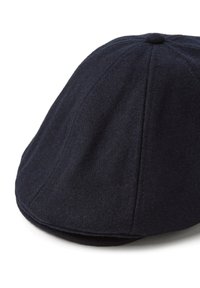 Gorra de lana azul marino oscuro con forma redondeada, que presenta un pico frontal, paneles cosidos y un pequeño detalle de botón en la parte superior.