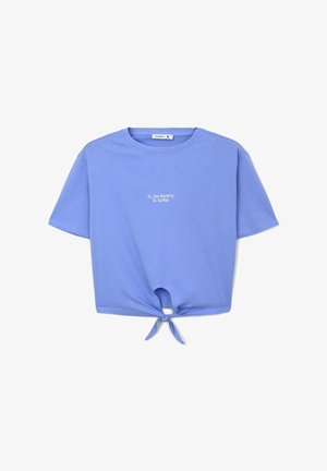 T-shirt cropped azzurro chiaro in cotone morbido con maniche corte, caratterizzata da un dettaglio nodo nella parte inferiore e testo bianco: “Sì, ma niente di serio.”
