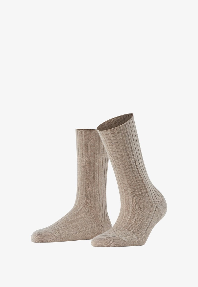 Calzini ribbed beige realizzati in un tessuto morbido e leggero. Presentano una punta rinforzata e una texture liscia. Adatti per un abbigliamento casual.