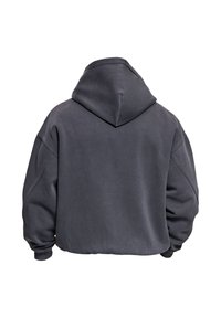 Sweat à capuche oversize gris foncé avec une capuche spacieuse, des épaules tombantes et des poignets côtelés. Texture lisse avec un design minimaliste.