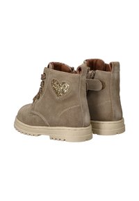 Beige suède enkellaarzen met een gestructureerde afwerking, voorzien van een sprankelende hartaccent, vetersluiting aan de voorkant en een beige rubberen zool.