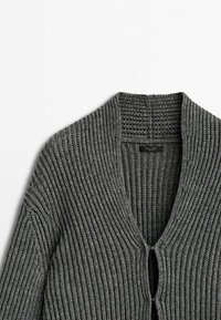 Cardigan en maille côtelée gris foncé avec col châle et fermetures à agrafes, présenté à plat sur fond blanc.