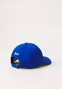 Căciulă de baseball albastră, fabricată din bumbac, cu o margine curbată, curea ajustabilă și logo brodat pe spate. Material texturat.