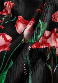 Tessuto nero con un motivo testurizzato presenta stampe di rose rosse e rosa disseminate, evidenziate da foglie verdi e un sottile logo rosa.