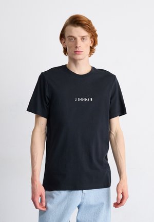 Tricou negru din bumbac cu mâneci scurte și decolteu rotund, având textul "JORDAN" în font alb, îndrăzneț și stilizat pe piept.