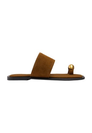 Brązowa, płaska sandałka z zamszu z szerokim paskiem na środku stopy i pętelką na palec z ozdobą z pozłacanej metalowej kulki na czarnej podeszwie.