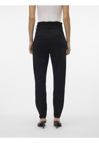 Pantalons noirs ajustés avec une taille haute, dotés d'une conception ceinturée, en tissu lisse et de deux poches arrière.