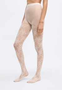 Διάφανο, γυμνό καλσόν με σχέδιο από λουλουδάτη δαντέλα, διαθέτοντας ψηλή μέση και ανοιχτή μύτη για επιπλέον άνεση.