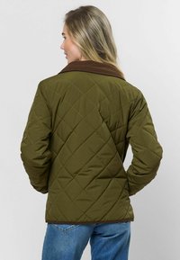 Olivovo zelená prešívaná bunda s hnedým kordovým golierom, s diamantovým vzorom a skráteným strihom. Viditeľné detaily šitia.