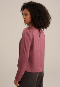 Halenka s dlouhými rukávy z jemné mauve látky, s lodičkovým výstřihem, nařasenými ramenními švy a decentním otvorem ve tvaru klíče na zadní straně.