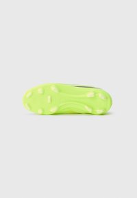 Neon grønn fotballsko såle med flere korte pigger for grep, vist mot en enkel lysegrå bakgrunn.