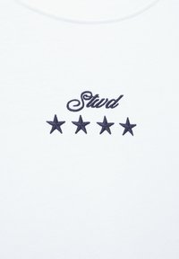 Biały materiał z czarnym wyszytym słowem „Stud” nad czterema czarnymi wyszytymi gwiazdami ułożonymi w poziomy rząd.