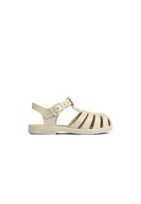Beige gummisandal med en remdesign, justerbar ankelrem och öppen t�å. Har en upphöjd logotyp på sidan och en platt sula.