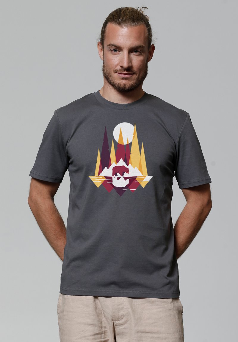 Dunkelgraues Baumwoll-T-Shirt mit einem geometrischen Druck auf der Vorderseite, der Berge, Bäume in Gelb-, Rot- und Weißtönen sowie ein großes Sonnendesign zeigt.