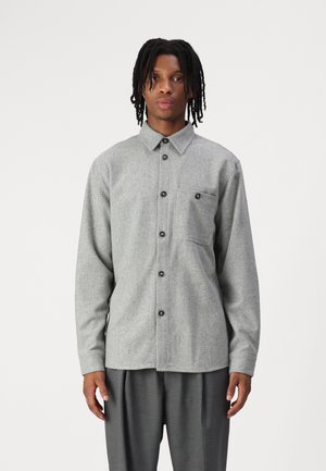 Gray flannel shirt featuring a button-down collar, front placket with black buttons, and a single chest pocket. Long sleeves, relaxed fit.